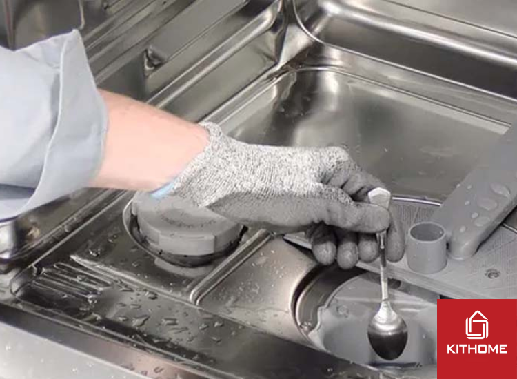 Dùng thìa nhỏ đặt chỗ nắp bơm để gỡ ra.