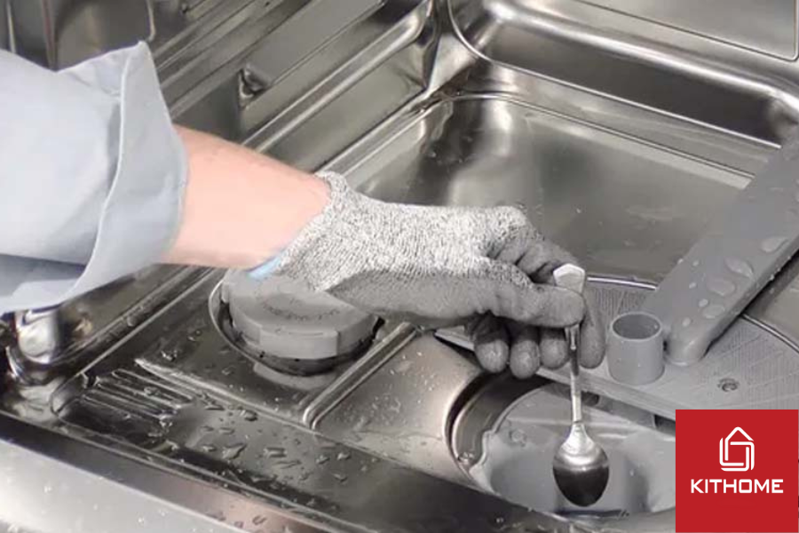 Dùng thìa nhò gỡ nắp máy bơm