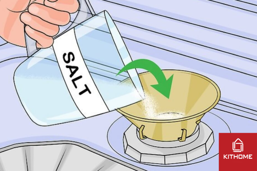 Đổ đầy muối vào hộc qua một chiếc phễu.