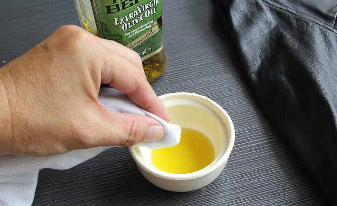 Dùng khăn mềm thấm dầu ô liu giặt để àm sạch áo da Dùng khăn mềm thấm dầu ô liu giặt để àm sạch áo da