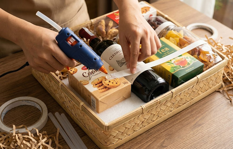 Cố định sản phẩm bằng keo hoặc băng dính giúp giỏ quà vững vàng, không xô lệch khi di chuyển Cố định sản phẩm bằng keo hoặc băng dính giúp giỏ quà vững vàng, không xô lệch khi di chuyển